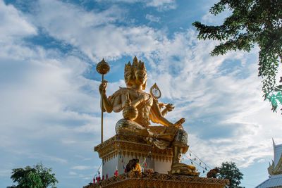 Low angle view of buddha statue against sky