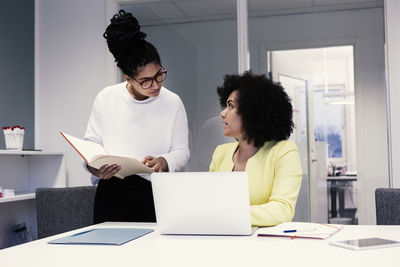 Women using laptop in boardroom