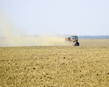 Scenic view of tractor on field against clear sky