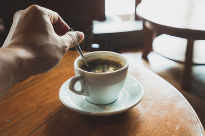 Person holding coffee cup on table