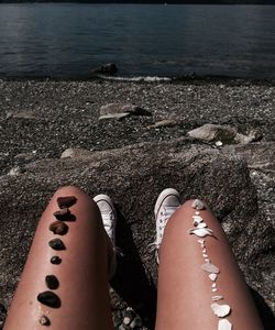 Low section of woman sitting on beach