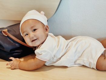 Portrait of cute baby lying on bed at home