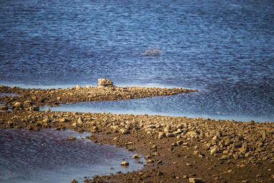 Sunny riverside landscape of a dried river bed and rocks. 