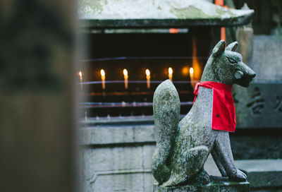 Statue against lit candles in temple