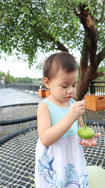 Cute girl holding ice cream cone outdoors