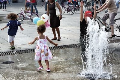 Kids enjoying at fountain in city