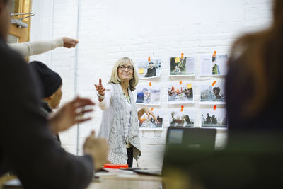 Senior businesswoman discussing with colleagues in meeting at board room