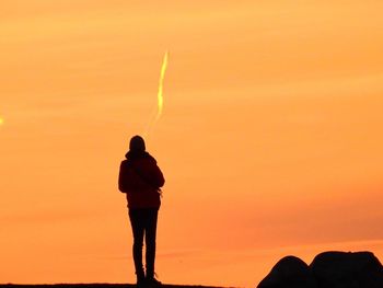 Rear view of silhouette man against sunset sky