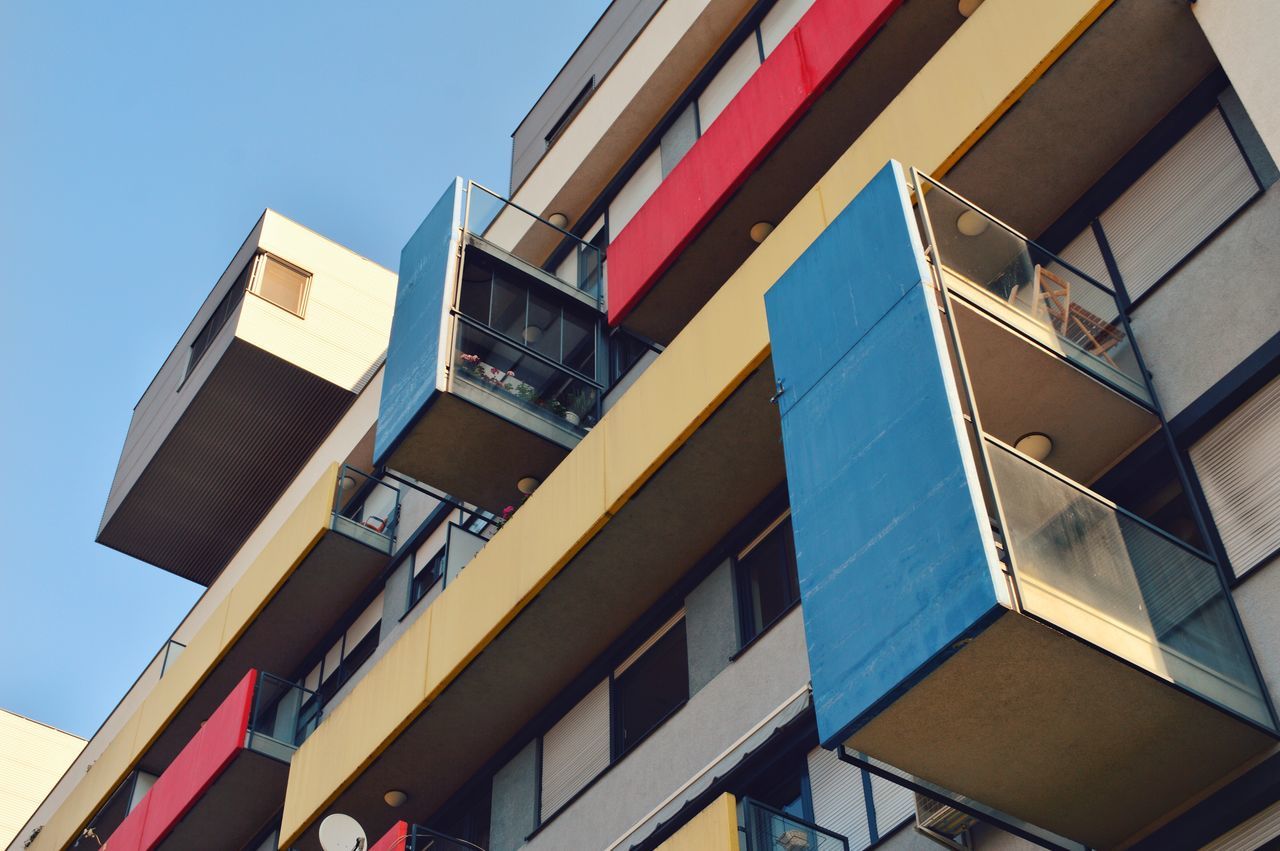 architecture, building exterior, built structure, low angle view, day, no people, outdoors, blue, clear sky, balcony, sky, multi colored, city