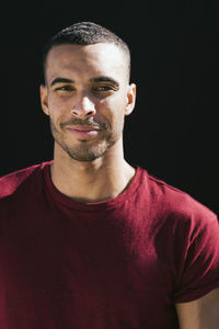 Portrait of young african american male against black back drop person