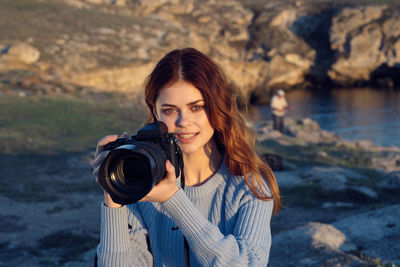 Portrait of young woman photographing camera