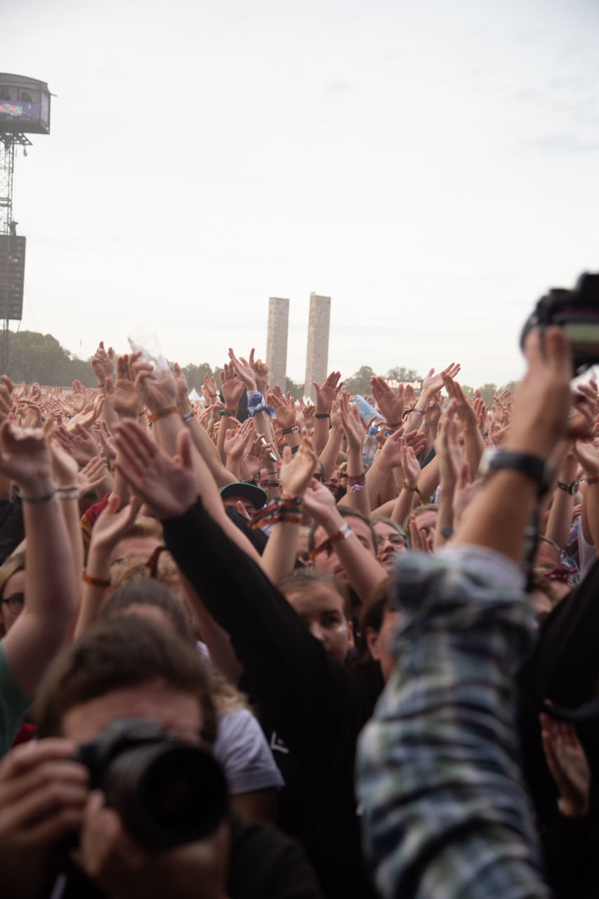 crowd, group of people, large group of people, real people, enjoyment, event, sky, women, human arm, music, arms raised, men, lifestyles, togetherness, hand, selective focus, youth culture, arts culture and entertainment, festival, excitement, music festival, outdoors, positive emotion, popular music concert, concert