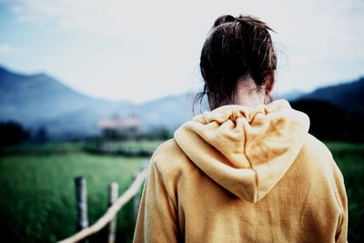 Rear view of woman standing on land against sky