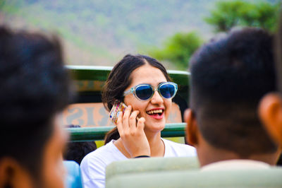 Smiling woman wearing sunglasses talking on smart phone 