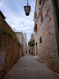 Empty narrow alley along buildings