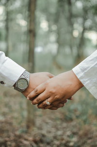 Close-up of hand holding hands against blurred background