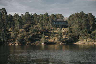 Scenic view of lake by trees against sky