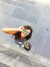 High angle portrait of smiling young woman on footpath