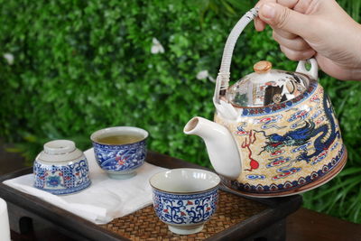 Hand holding tea cup on table