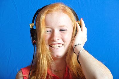 Portrait of smiling young woman against blue sky