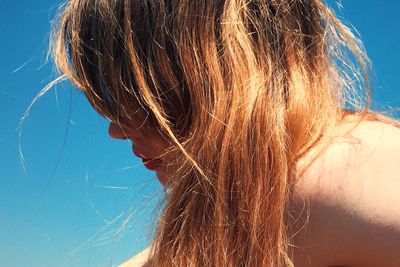 Close-up of shirtless blond woman against clear sky