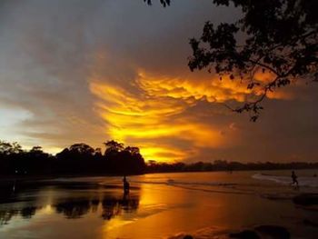 Scenic view of sea against cloudy sky at sunset