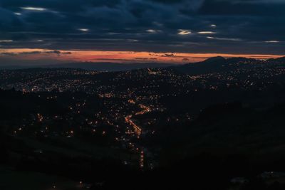 Aerial view of illuminated cityscape against sky at sunset