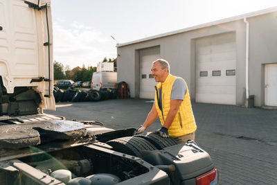 Smiling man leaning on trailer tyre