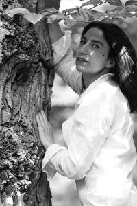 Low angle view of woman standing on tree trunk