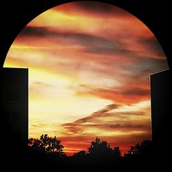 Low angle view of silhouette building against cloudy sky