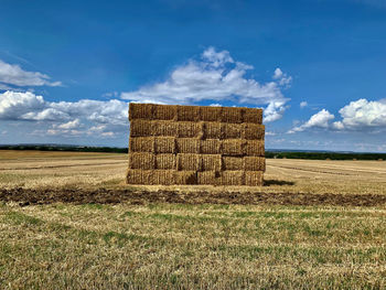 Hay bales on field against sky