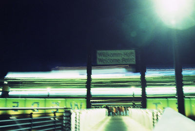 Low angle view of sign board and illuminated harbor at night