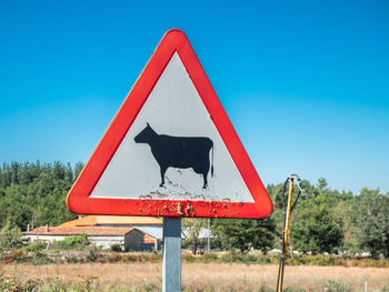 Road sign against clear blue sky