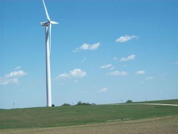 Low angle view of windmill on field against sky