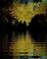 Silhouette trees by lake in forest against sky