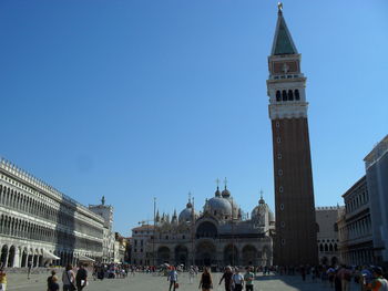 Group of people in front of building against clear sky