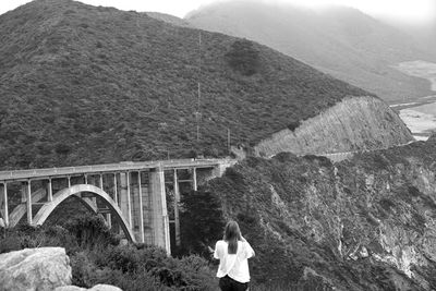 Rear view of man on bridge against mountain