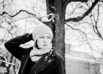 A girl posing in front of winter tree in snow