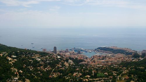 High angle view of cityscape by sea against sky