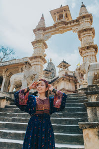 Woman standing against historic building