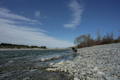 Man crouching by river