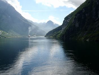 Scenic view of river and mountains against sky