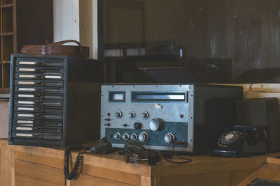 Close-up of old telephone booth on table