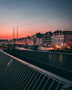 View of illuminated cityscape against sky during sunset