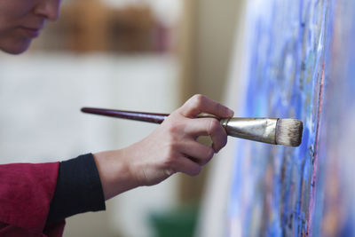 Midsection of woman painting on canvas