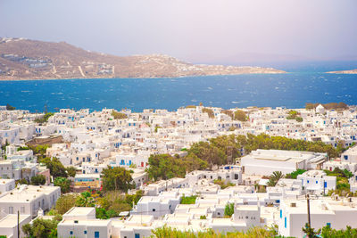 High angle view of townscape by sea against sky