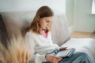 Girl teenager uses tablet learning home