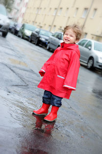 Full length of boy with umbrella on road