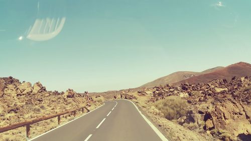 Road amidst desert against sky