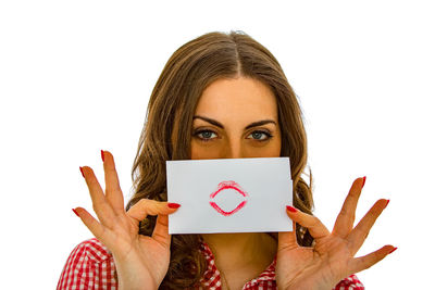 Portrait of woman holding hat against white background